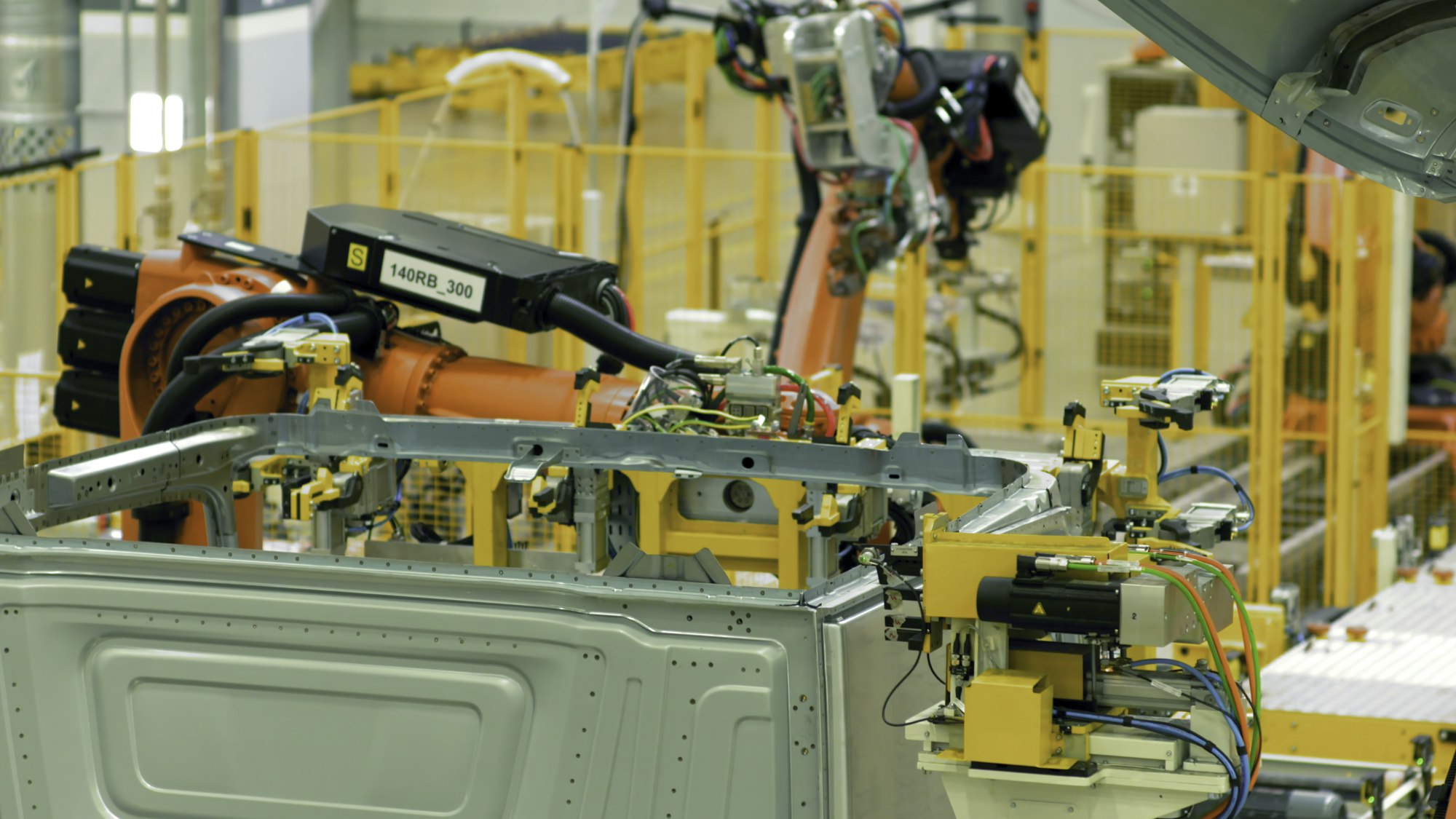 Automated car assembly at factory. Scene. Automated machines assemble metal structure at enterprise